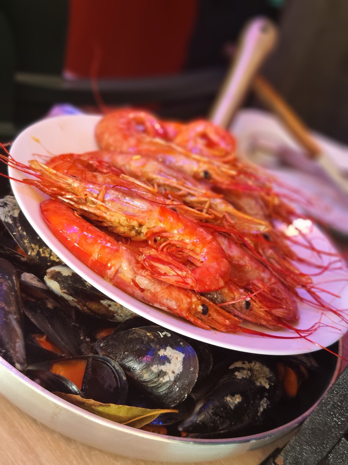 Gambas grelhadas sobre uma panela de mexilhões