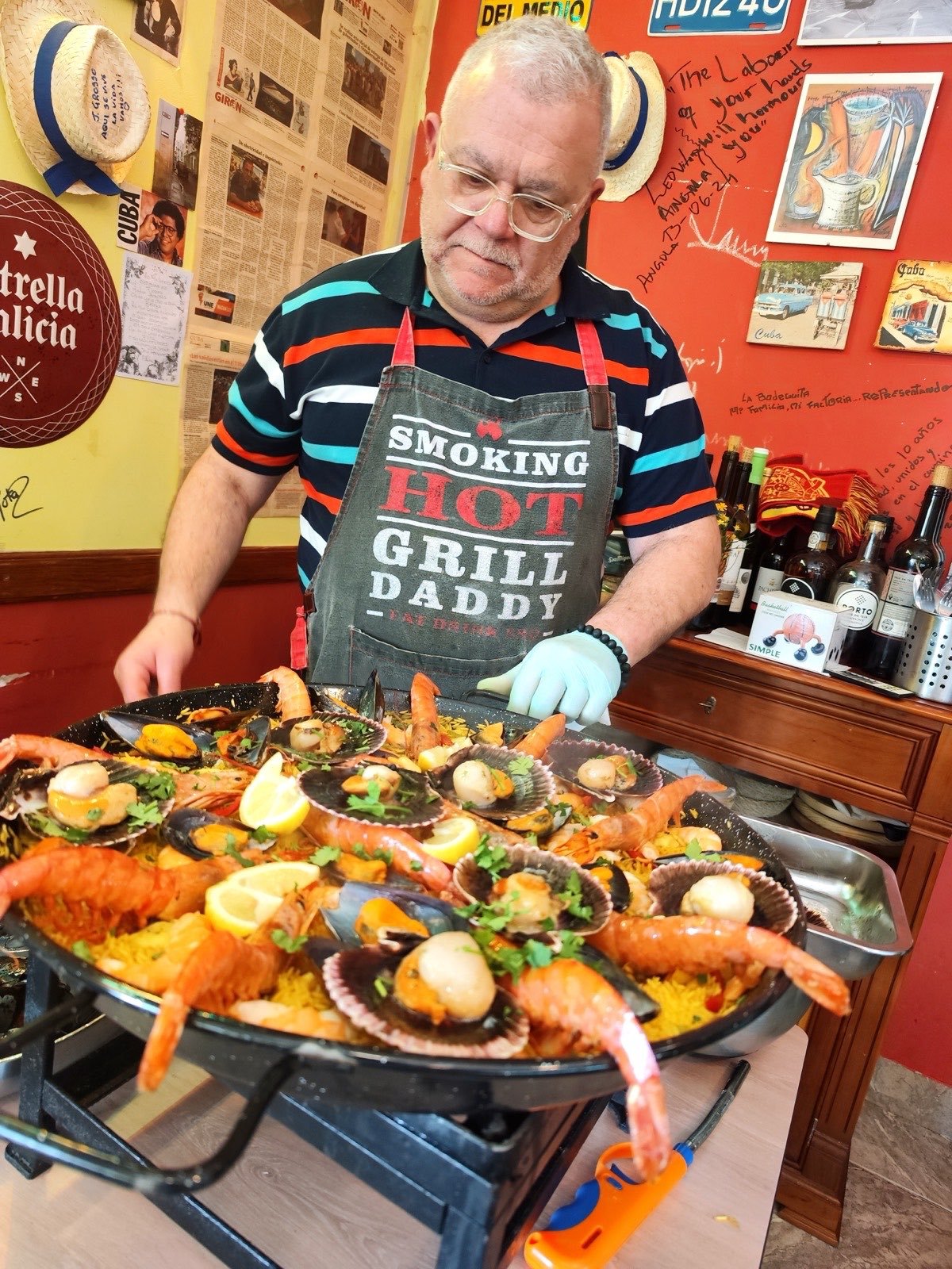 O dono da La Bodeguita a segurar a paellera com a paella pronta